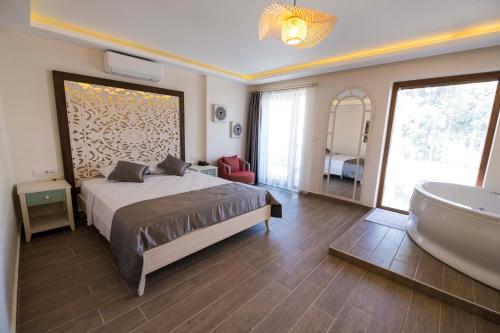 a bedroom with a bed and a tub and a sink at Icarus Alaçatı in Çeşme