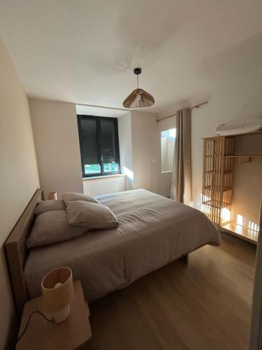 a bedroom with a large bed and a window at Gîte Le Valeix in Neuvic