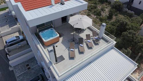an overhead view of a pool with chairs and an umbrella at Luxury Loft Apartment Mandre in Mandre