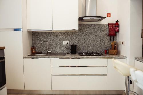 a white kitchen with white cabinets and a stove at Staytopus Kenn is Sur - Citadel Victoria Gozo Hideaway - Pool in Victoria