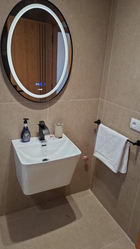 a bathroom with a white sink and a mirror at Villa Sereine in Sidi Yahia