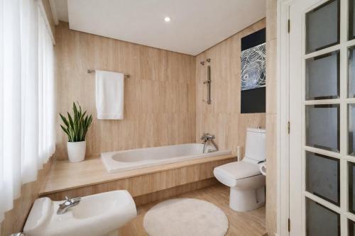 a bathroom with a tub and a toilet and a sink at LÚA Cies Room in Oya