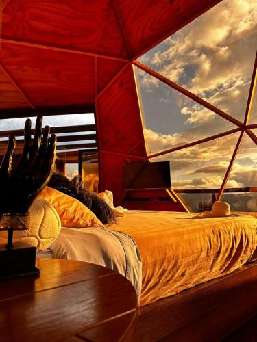 a bed in a room with a large window at Imperios Glamping in Silvania