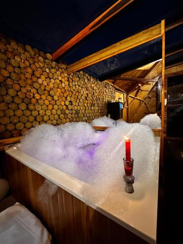 a bath tub filled with snow with a candle at Imperios Glamping in Silvania