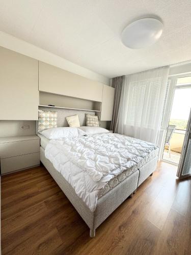 a bedroom with a large bed and a large window at Sinteu 3 bedroom apartment - 6PAX in Şinteu
