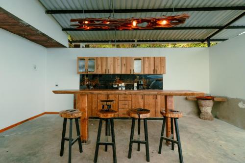 a kitchen with a wooden counter and stools at Las Trincheras del Café in Chaparral