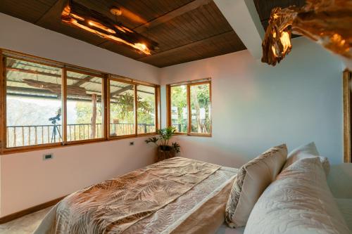 a bedroom with a bed in a room with windows at Las Trincheras del Café in Chaparral