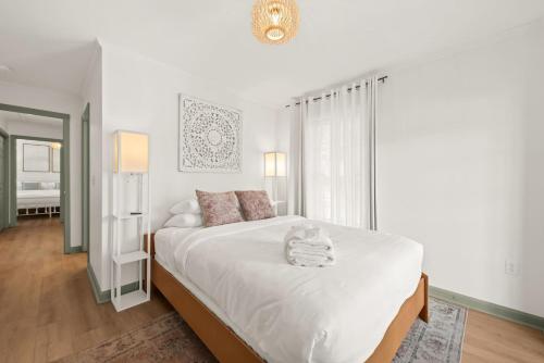 a white bedroom with a large bed and a mirror at Charleston 3BR Home · 3 Baths · Porches · Dogs OK in Charleston