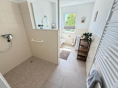 a bathroom with a shower and a toilet and a sink at RegioStyle Gemütliche Wohnung im Schaalseepark! in Zarrentin