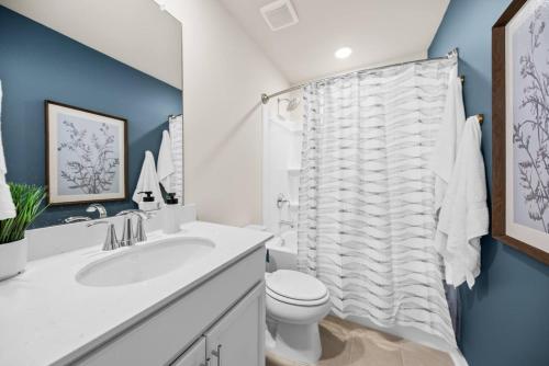 a bathroom with a white toilet and a sink at Sweetgrass Row at Cane Bay in Summerville