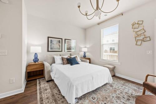 a white bedroom with a bed and a couch at Sweetgrass Row at Cane Bay in Summerville