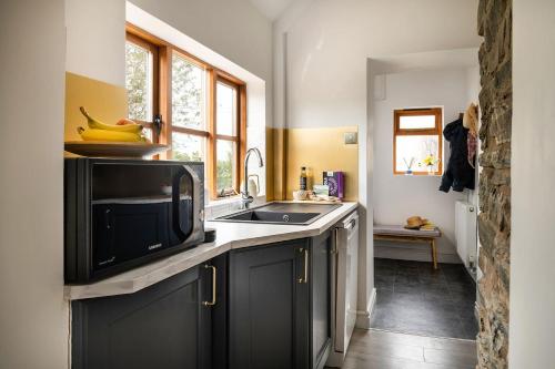 a kitchen with a sink and a microwave at Lovely 2 Bedroom Countryside Retreat in Shelve