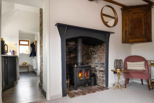 a fireplace in a living room with a stove at Lovely 2 Bedroom Countryside Retreat in Shelve