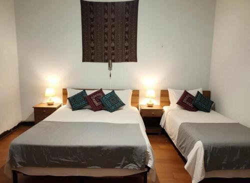 two beds in a room with two lamps at Wind & Way Hostel in Valparaíso