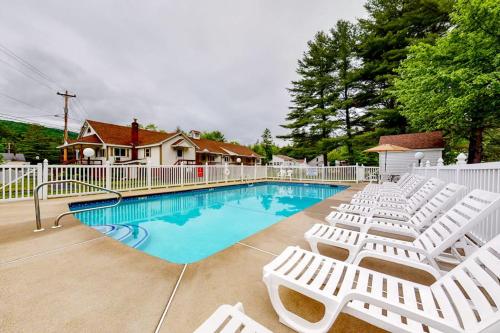 a swimming pool with white chairs and a fence at Charming and casual motel in a great location with shared resort amenities in Lincoln