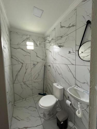 a white bathroom with a toilet and a sink at Loft urbano in Martins