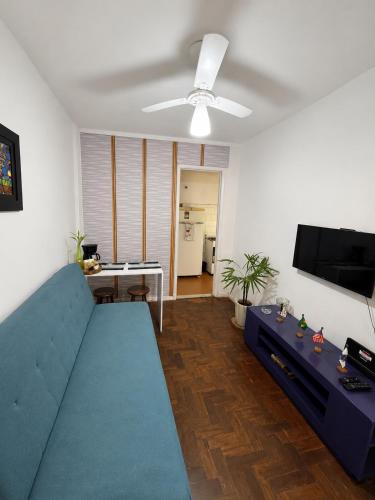 a living room with a blue couch and a flat screen tv at Apartamento em Botafogo 5 min de Copacabana in Rio de Janeiro