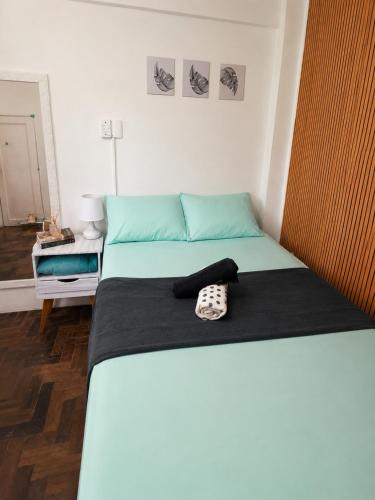 a bed with a hat sitting on top of it at Apartamento em Botafogo 5 min de Copacabana in Rio de Janeiro