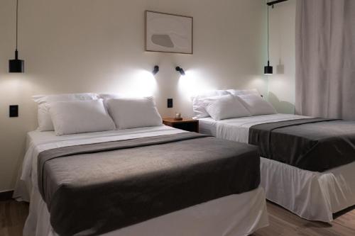 two beds sitting next to each other in a room at Hotel Casa Arbórea in San José