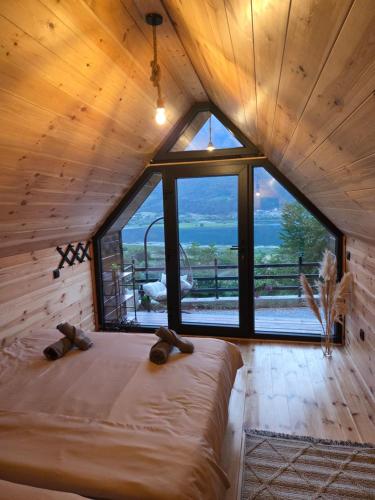 a bed in a room with a large window at Eagle's View Cabin in Plav