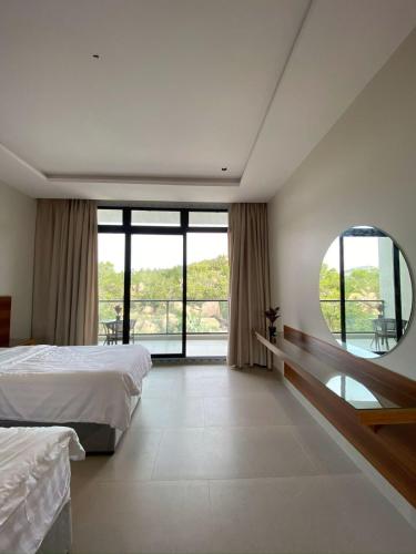 a bedroom with two beds and a large window at الدغيثر للشقق المخدومه in Ash Shafa