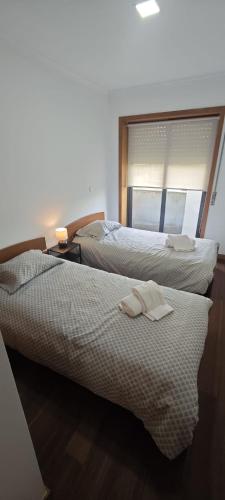 two beds in a hotel room with towels on them at 2 Bedrooms Apulia Front Beach Flat in Apúlia
