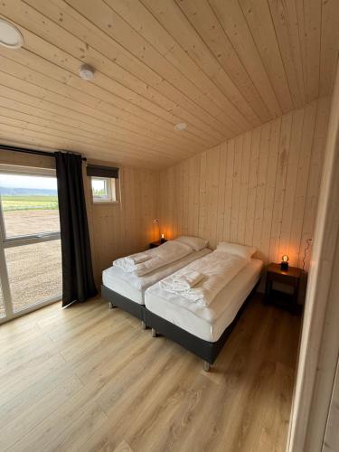 a bedroom with two beds in a room with a window at Sefdalur in Höfn