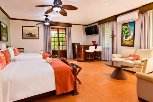 a bedroom with two beds and a couch at Hotel Casa Roland Golfito Resort in Golfito