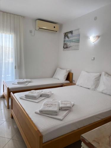 two beds in a room with towels on them at Apartmani Miladinović in Sutomore