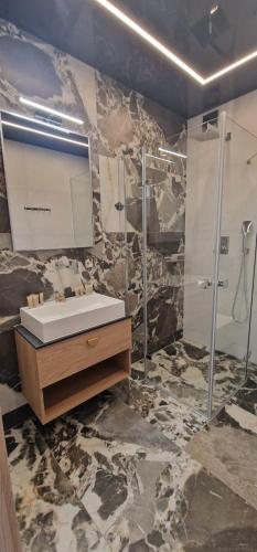a bathroom with a sink and a mirror at Sea Apartments in Łeba