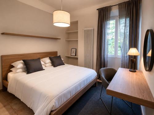 a bedroom with a bed and a desk and a window at Casa Vacanza Saint George - Hotel San Giuseppe Group in Cernobbio