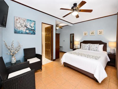 a bedroom with a bed and a ceiling fan at Hotel Espadilla Gardens in Quepos