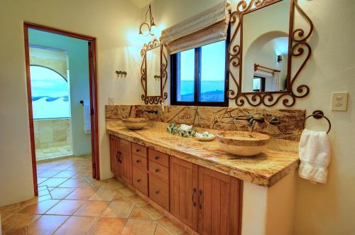a bathroom with two sinks and a mirror at Las Palmas Oceanfront Villas and Casitas in Santa Cruz Huatulco