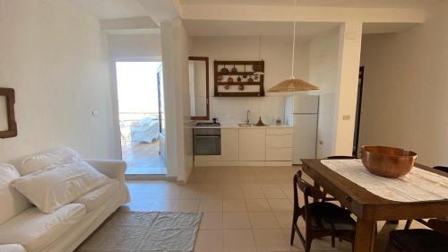 a living room with a white couch and a table at Terrazzo Vista Mare Mozzafiato in Cariati