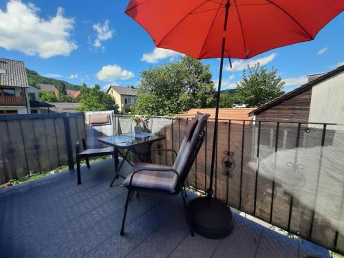 a patio with a table and a red umbrella at Ferienwohnung Purwins in Ebermannstadt