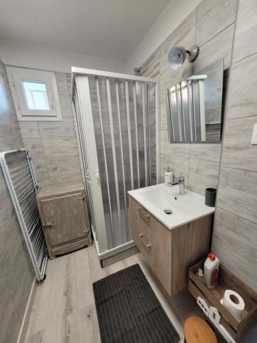 a bathroom with a white sink and a shower at Tahiti Beach, T2 à la mer, piscine, terrasse et parking in Frontignan