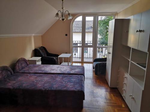 a bedroom with a bed and a living room at Kossuth Apartman in Hajdúszoboszló
