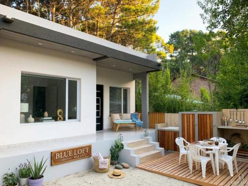a house with a deck with a table and chairs at Mar azul Loft in Mar Azul