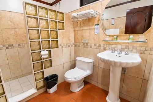 a bathroom with a toilet and a sink at Hotel Casa Roland Golfito Resort in Golfito