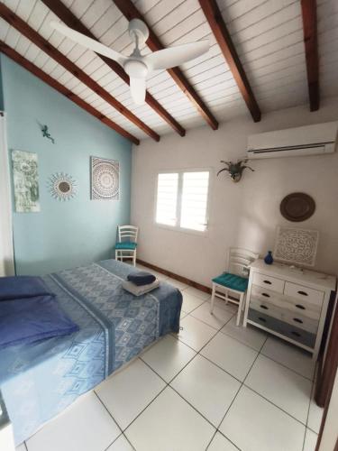 a bedroom with a bed and a dresser and a ceiling at Villa Rosa Karibella in Saint-François