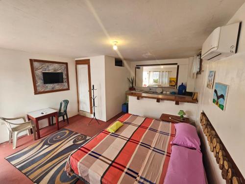 a bedroom with a bed and a table and a desk at Mí Oficina in Puerto Ayora