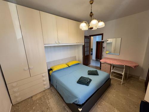 a bedroom with a bed with yellow pillows and a desk at Appartamento ad Andora a soli 5' dal mare in Laigueglia