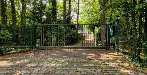 an open gate in a park with a walkway at Villa Albert in Euskirchen