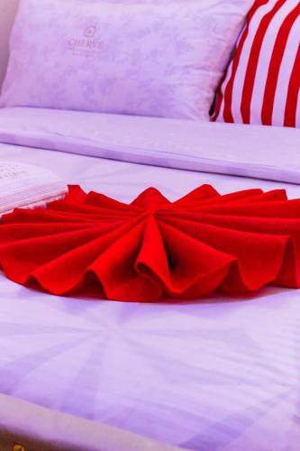 a red satin bow tie on a bed at Cherve BnB in Nakuru