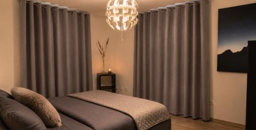 a bedroom with a bed and a chandelier at Acorn Hill Apartments in Nidda