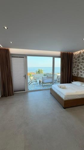 a bedroom with a bed and a view of the ocean at ALAR Rooms in Dhërmi