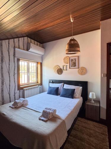 a bedroom with a large bed with towels on it at Casa da presa in Ponte de Lima
