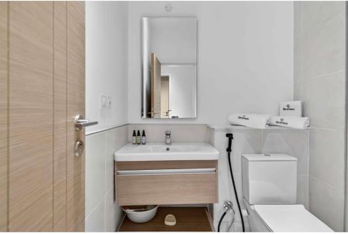 a bathroom with a sink and a toilet and a mirror at Marassi in El Alamein