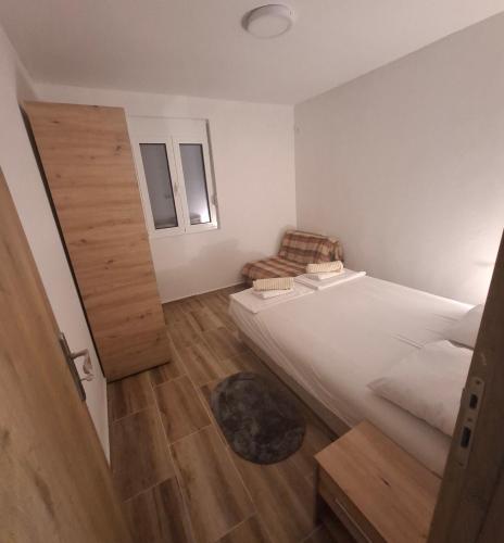 a small room with two beds and a chair at Nido Apartman in Kotor