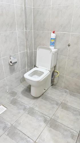 a bathroom with a toilet in a tiled room at Kaizen Homes in Homa Bay